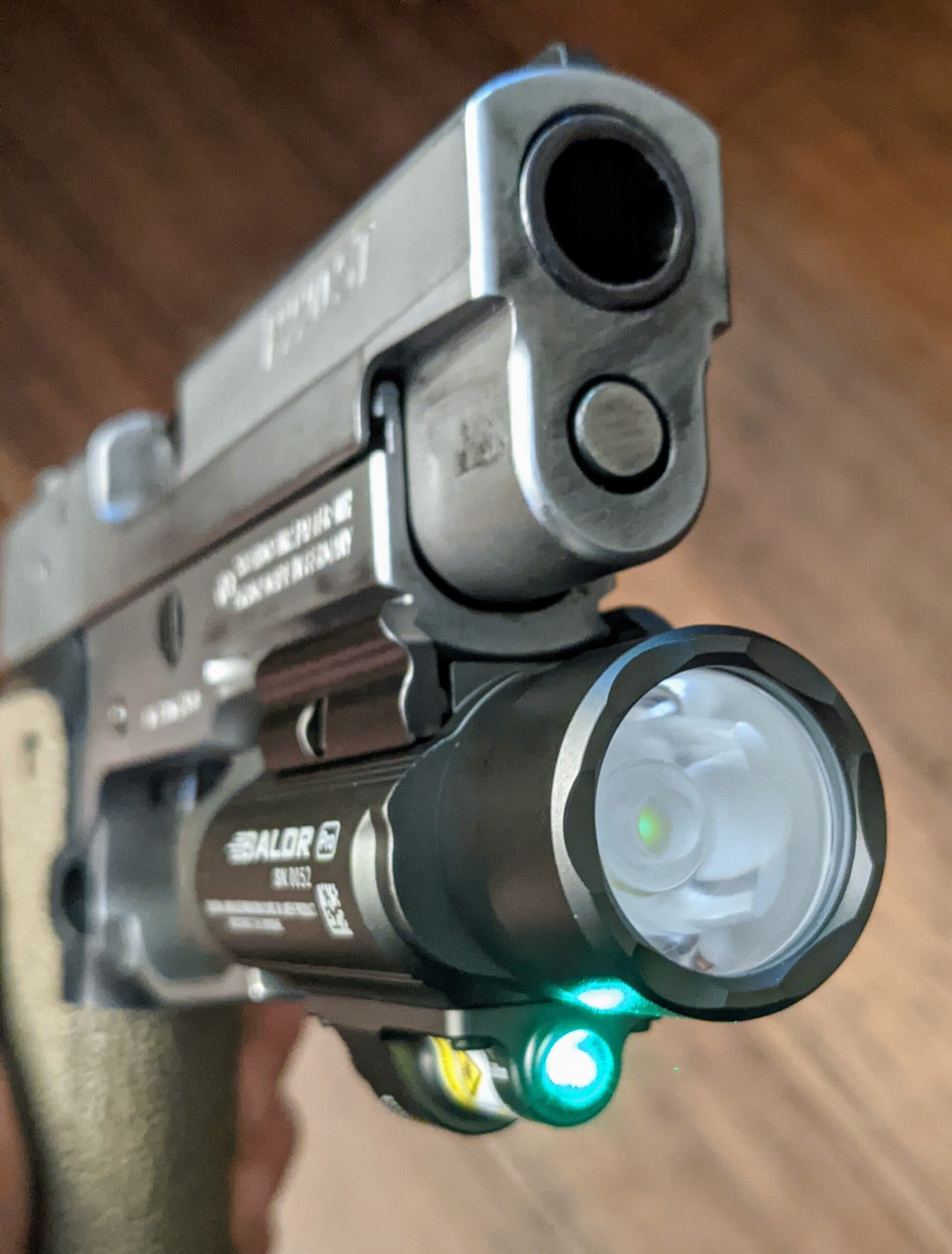 Olight Baldr Pro with green laser emitter powered on.