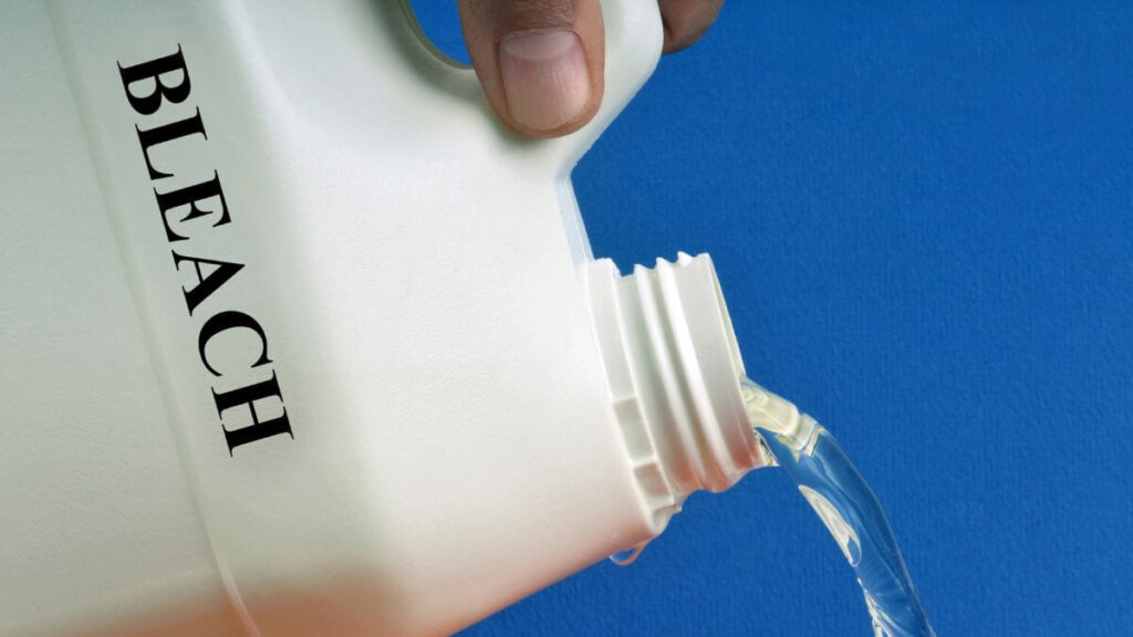 man pouring jug to purify water with bleach