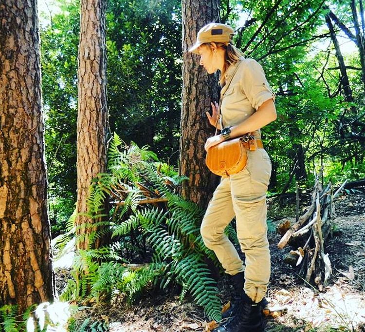 Woman searching out a site for a hidden bushcraft shelter