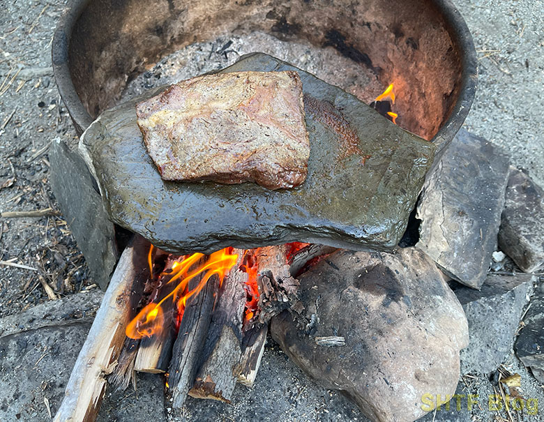 steak on a stone over a fire