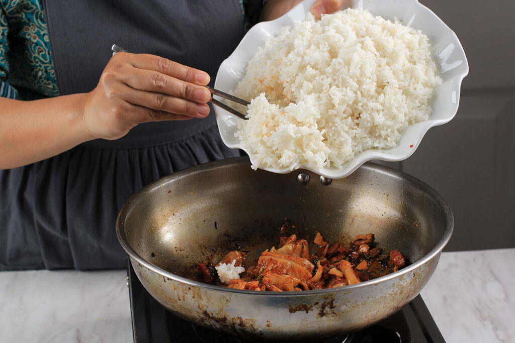 white rice being added to a pot on the stove