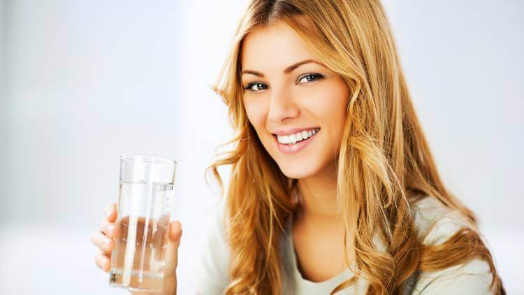 woman holding glass of purified water